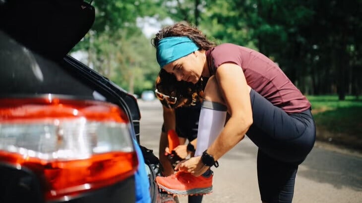 A beginner 50K athlete ties up their spare pair of shoes that they brought just in case.