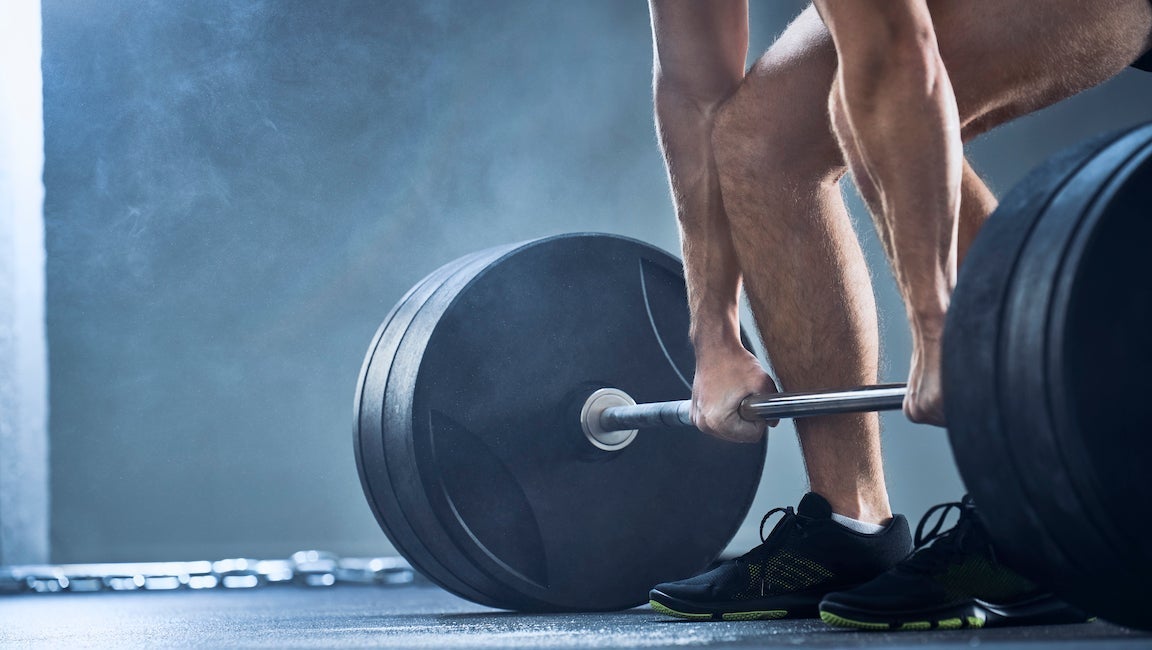 Muscular fitness man preparing to deadlift a barbell over his head in  modern fitness center. Functional training. Snatch exercise Stock Photo |  Adobe Stock