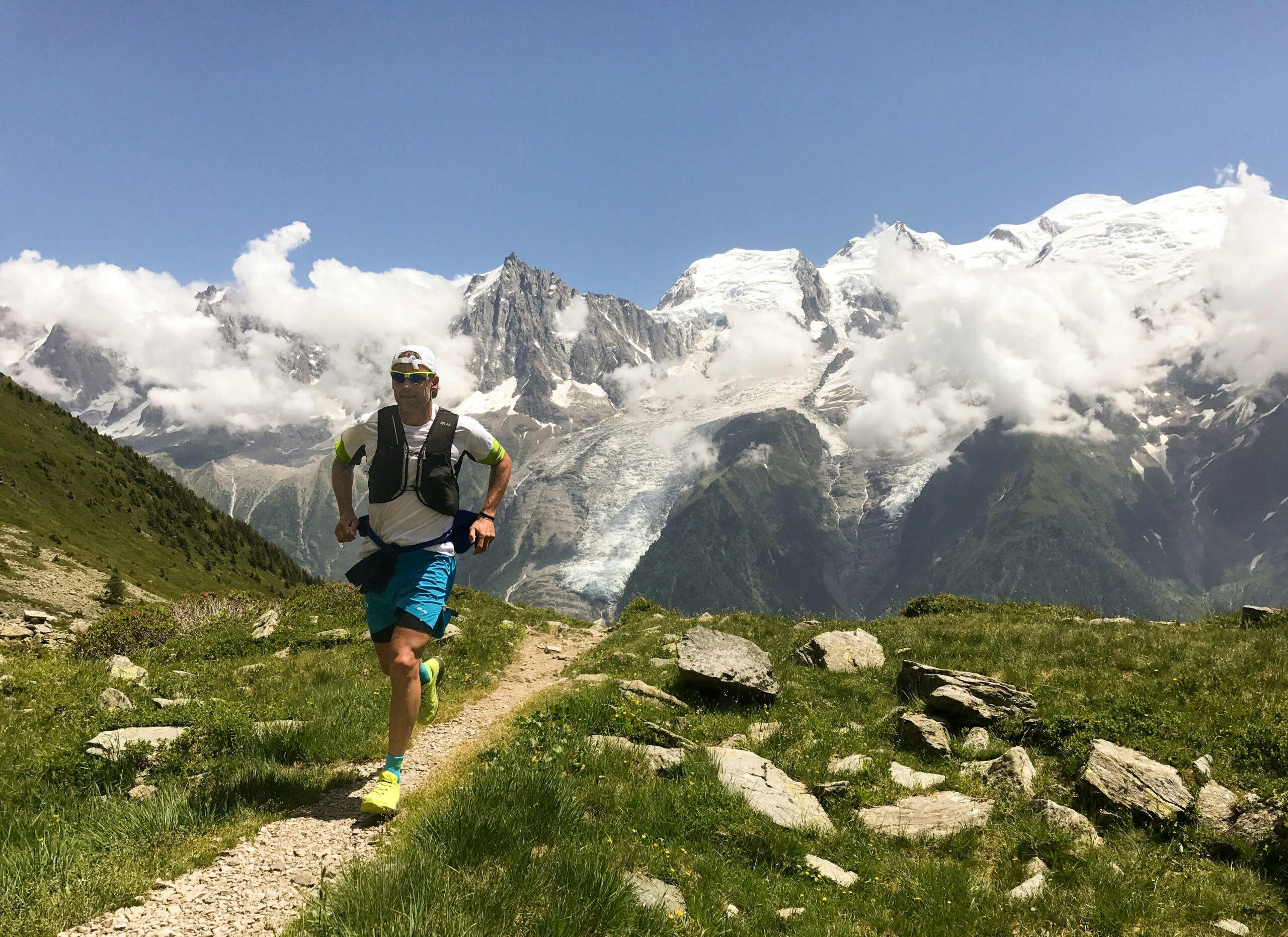 a trail runner jogs during a 50k race in the alps on a sunny day
