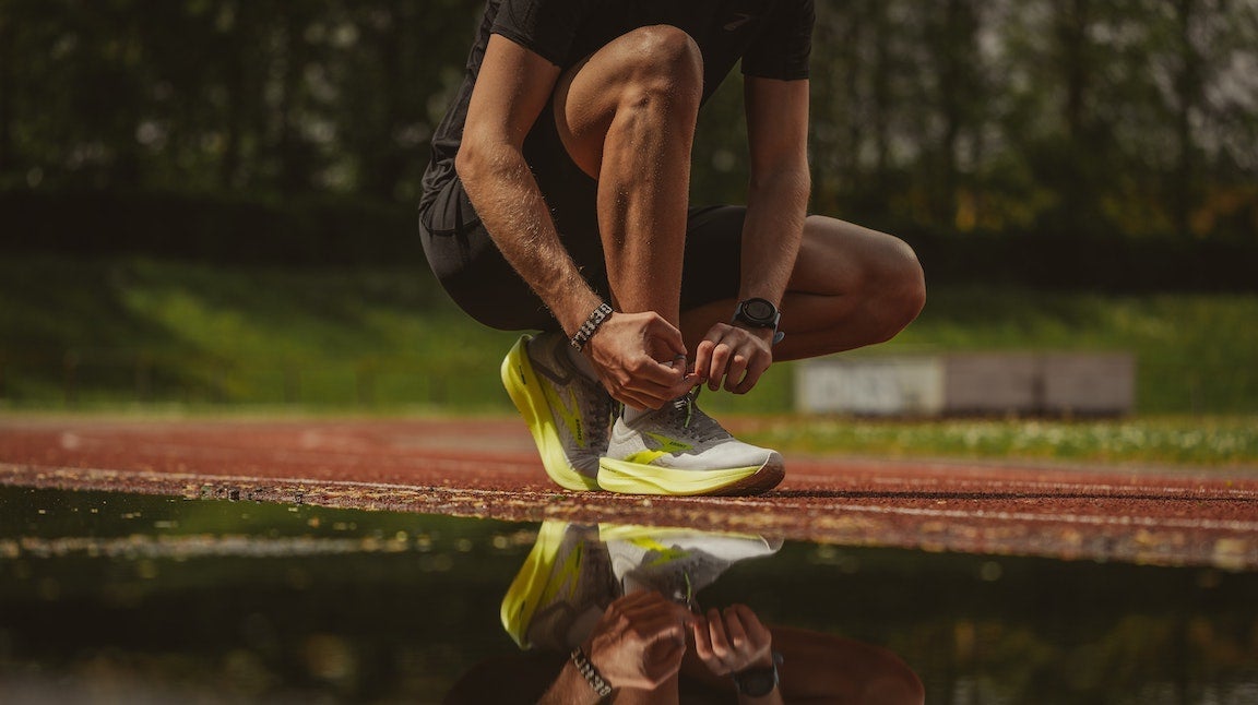 Man lacing up shoe while exploring how to start running again.