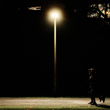 A single person runs on a track in the middle of the night.