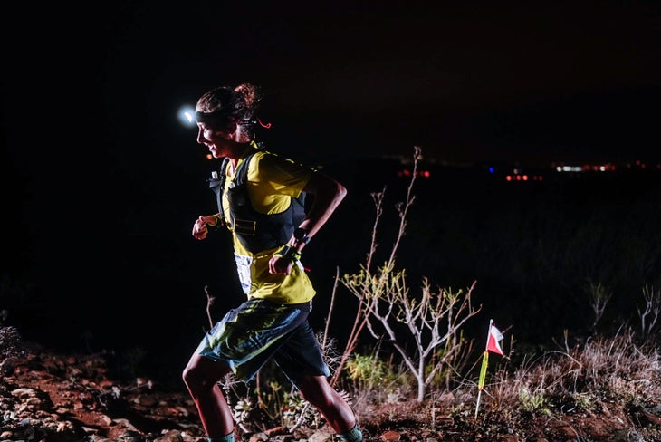 Courtney Dauwalter smiles while running through the night at Transgrancanaria