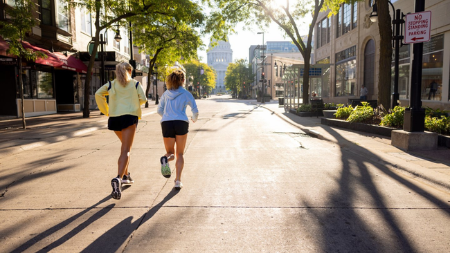 two women run on state street in Madison, WI