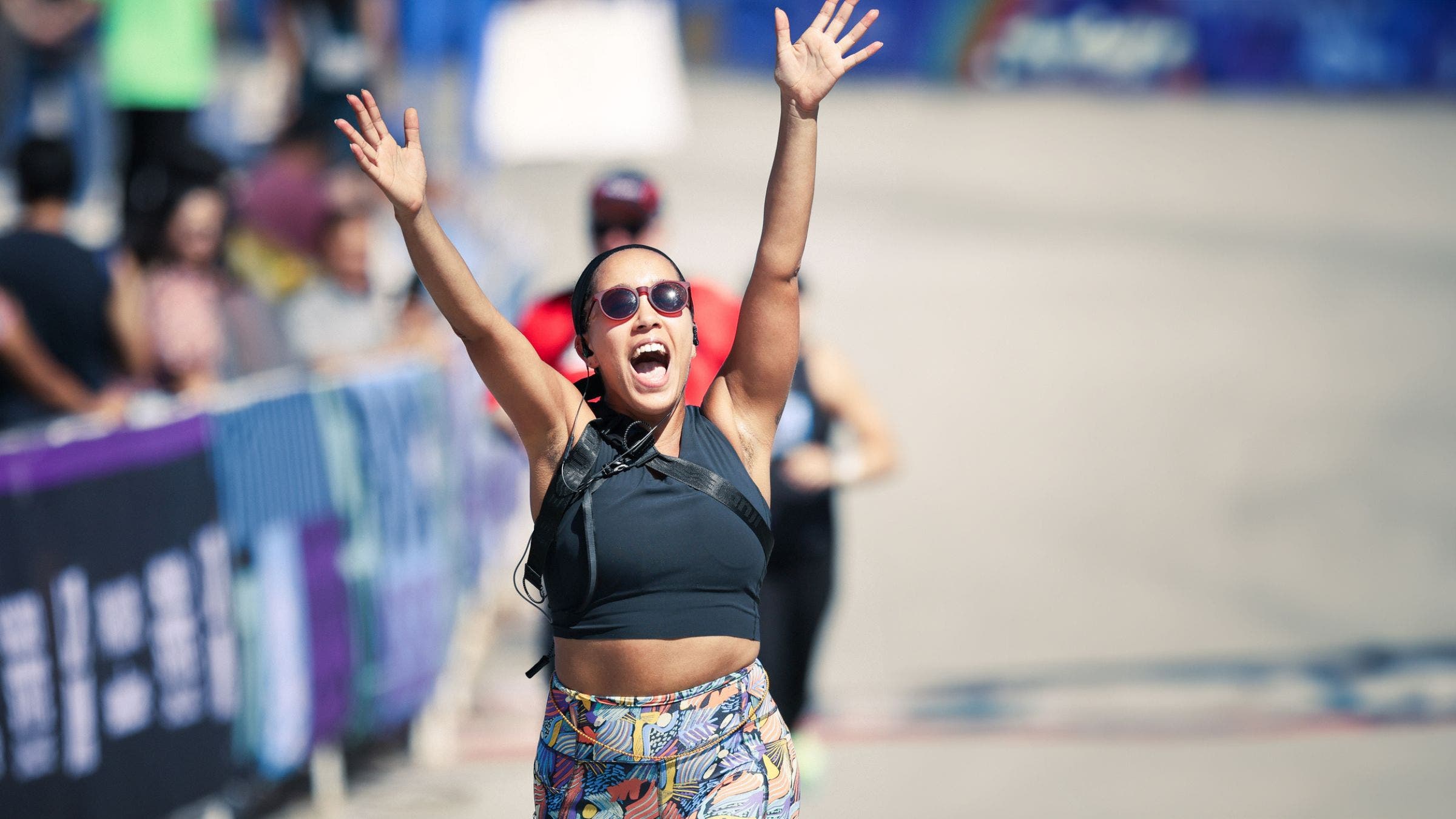 Woman celebrating finish line crossing.