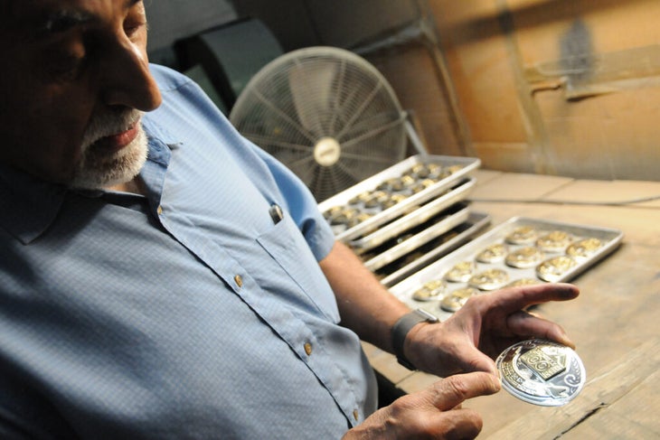 Serafin Sanchez inspects a Leadville 100 buckle on August 12 at his Colorado Silver Star office in Denver.