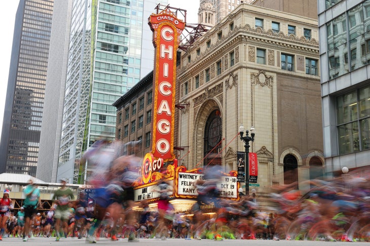 Runners pass the Chicago Theatre during the 2024 Chicago Marathon on October 13, 2024 in Chicago, Illinois.