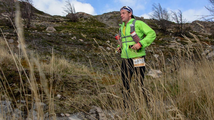 Brian running a trail race in Chile through tall grass and mountains. 