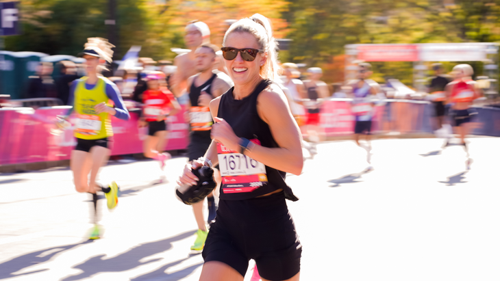 A woman dressed in black approaches the New York City Marathon Finish Line