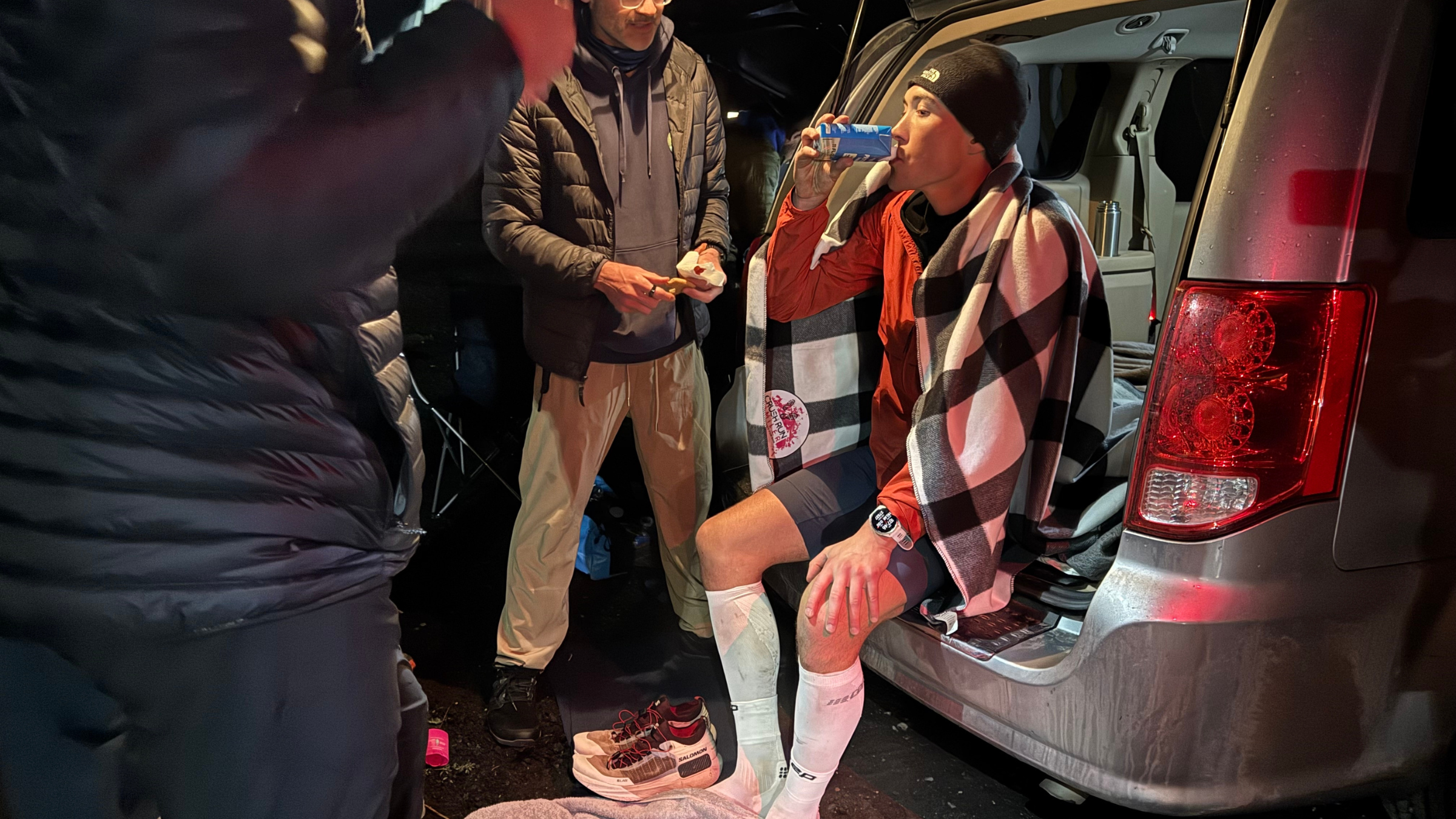 a man in the back of the van covered in a blanket running the cocodona 250