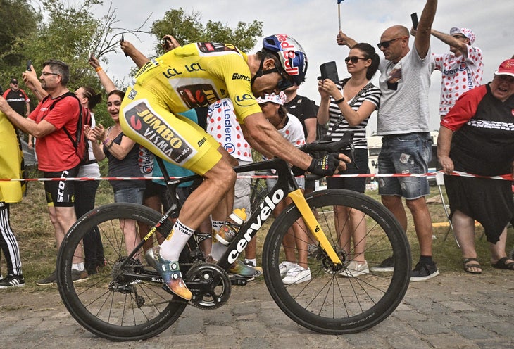 Jumbo-Visma team's Belgian rider Wout Van Aert wearing the overall leader's yellow jersey cycles across a cobblestone sector during the 5th stage of the 109th edition of the Tour de France cycling race, 153,7 km between Lille and Arenberg Porte du Hainaut, in northern France, on July 6, 2022. (Photo by Marco BERTORELLO / AFP) (Photo by MARCO BERTORELLO/AFP via Getty Images)