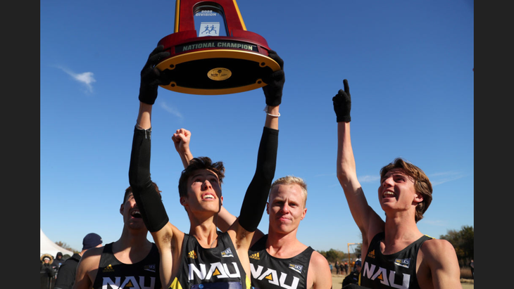 cross country runners holda national champion trophy.