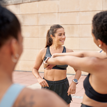 a woman running coach stands in front of runners getting ready for a group run.