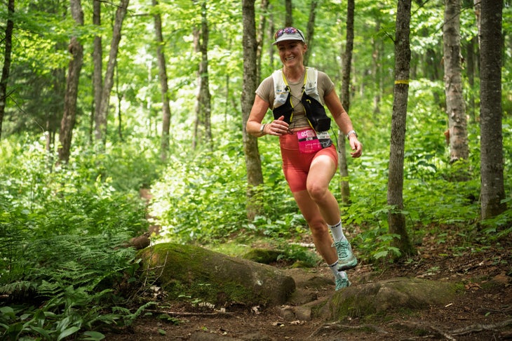 A QMT participant runs through the woods.