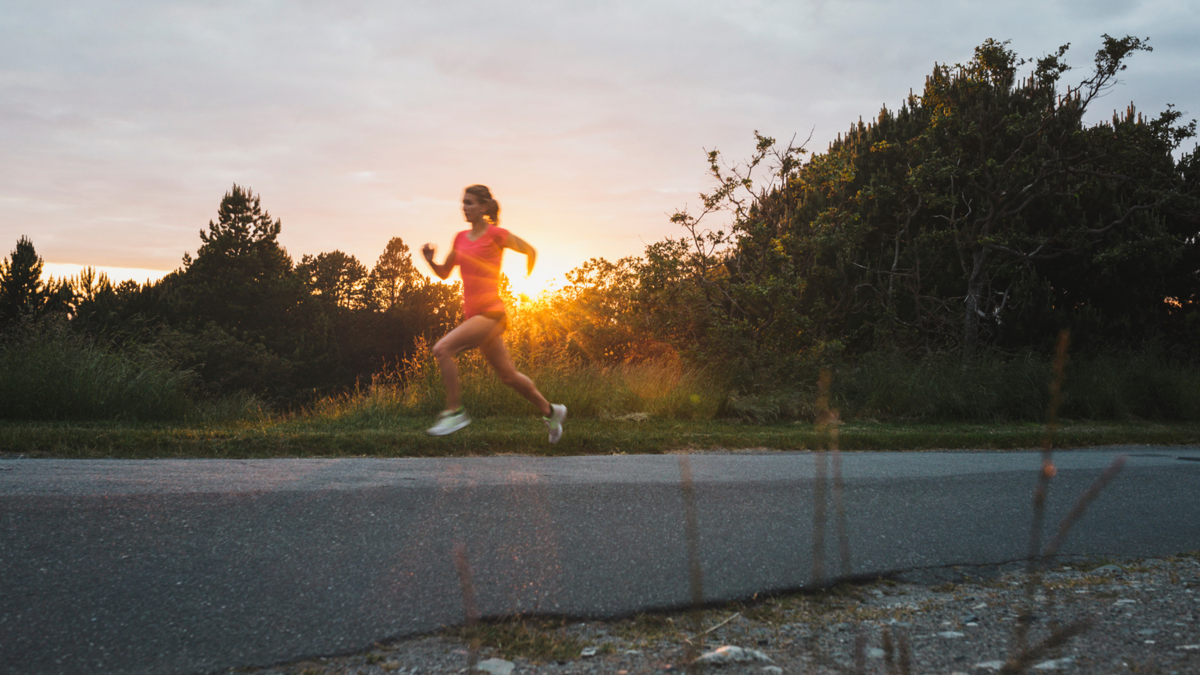a woman runs as the sun rises