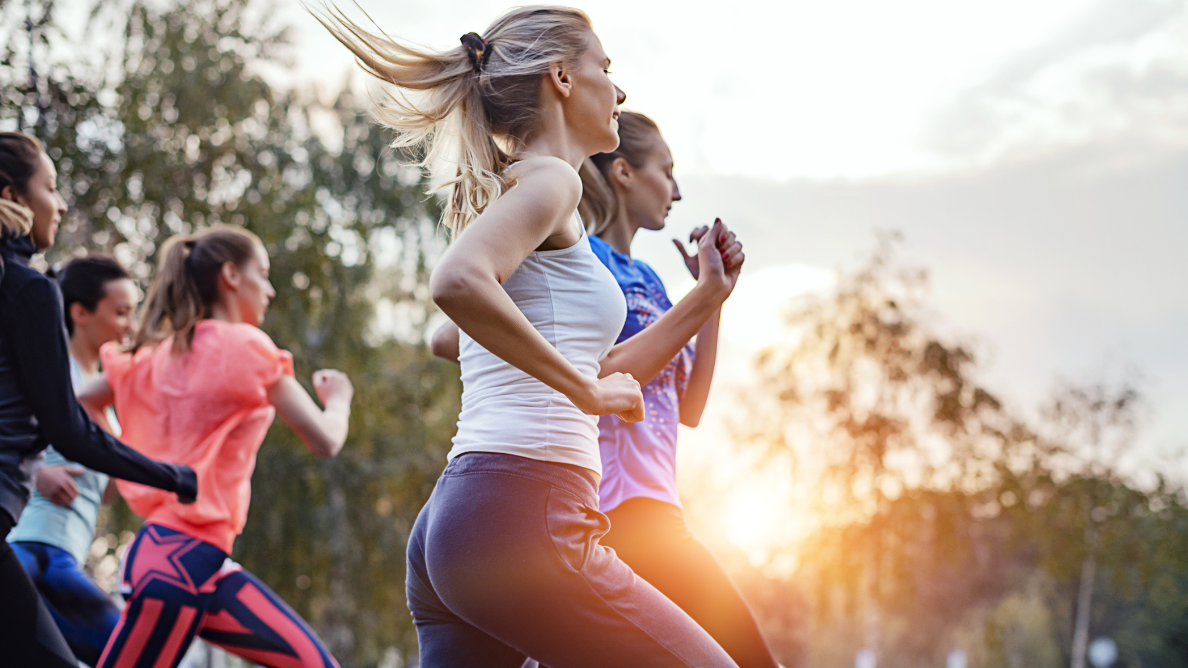 a group of women runners tackling a tough run together in the sunrise