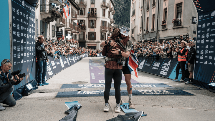 Tom Evans celebrates winning UTMB 2025 by embracing his wife and five-month-old daughter.
