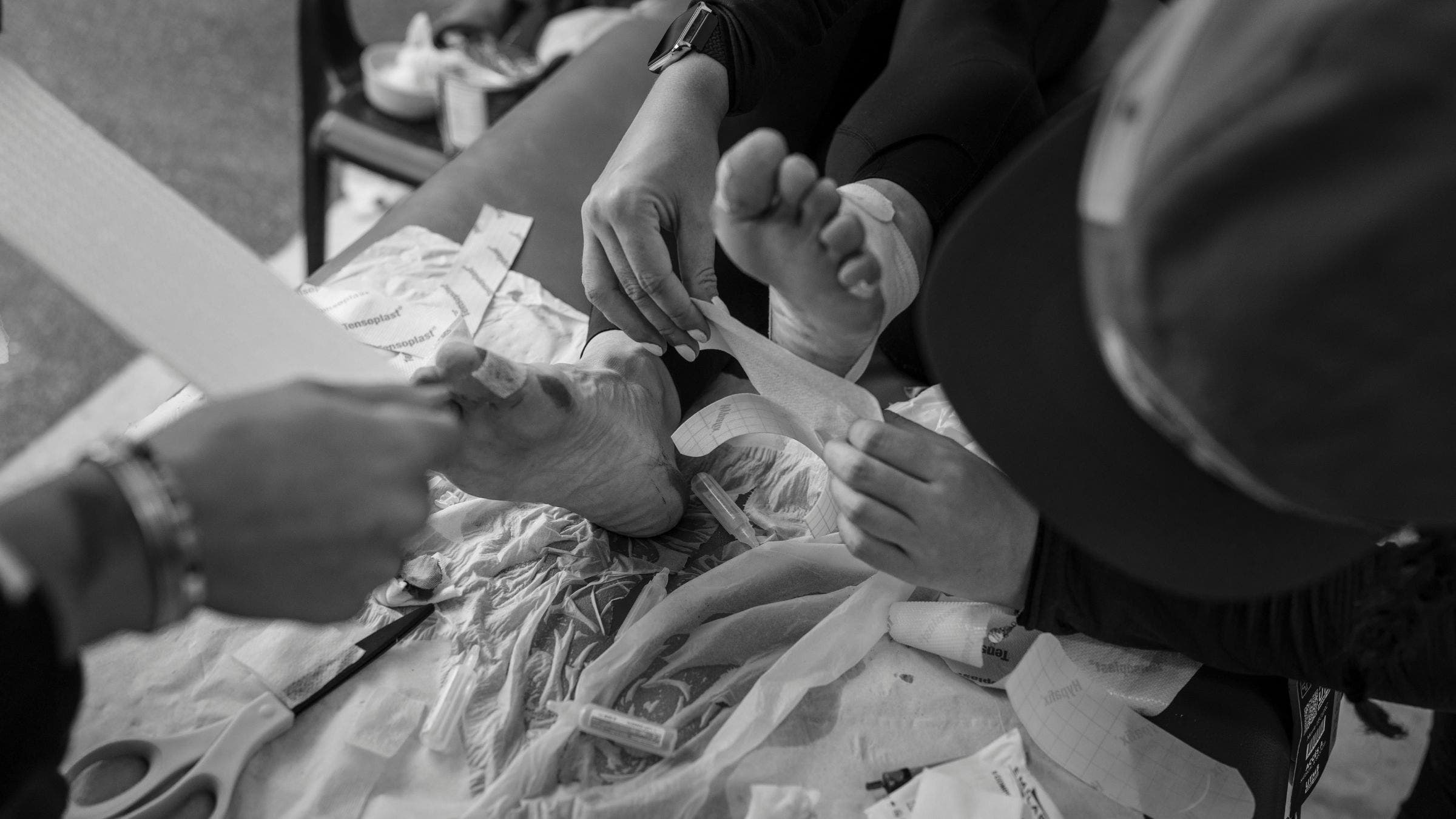 A racer bandages their feet at the 2025 UTMB.