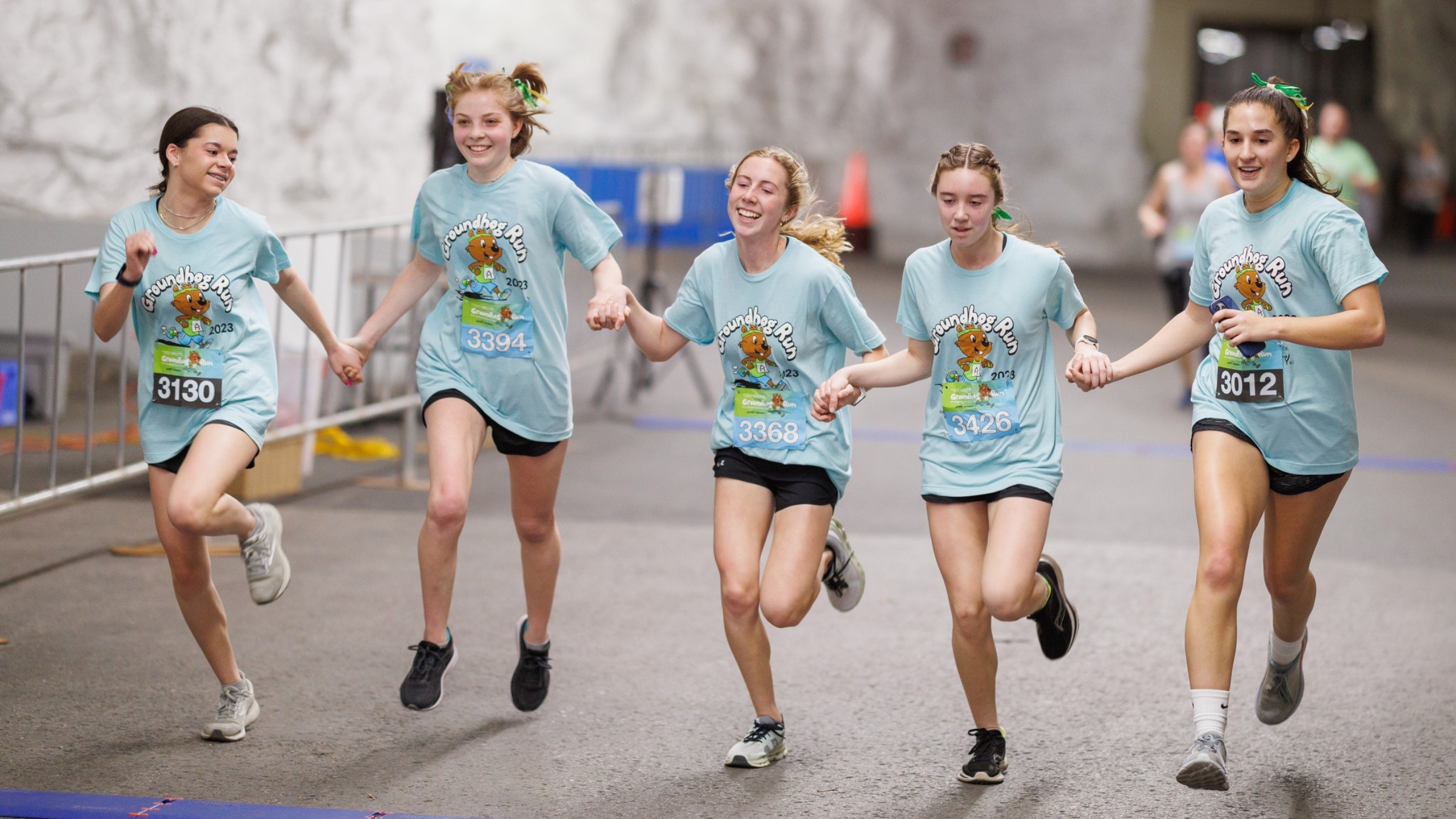 a group of girls runs a race in matching shirts