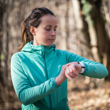 a woman checks her watch while running