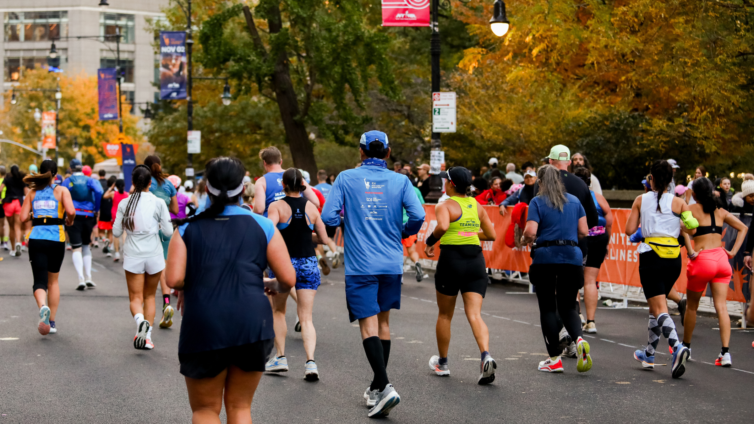 the back of runners in the New York City Marathon as they approach the finish line