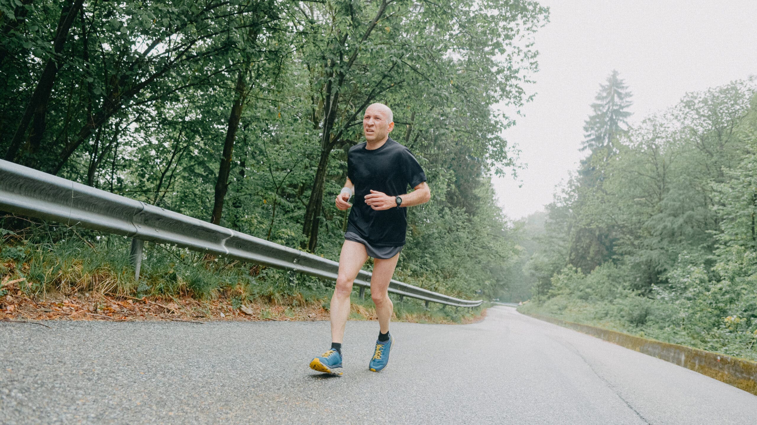 A male runner heads uphill during a new workout to break through a running plateau.