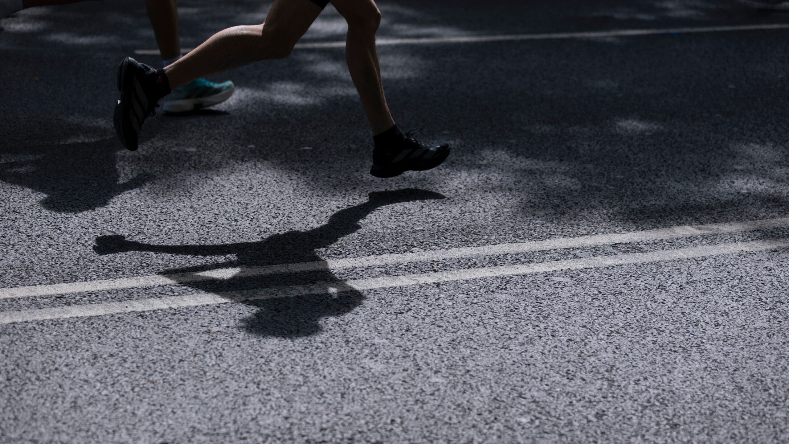 The legs of an athlete are shown during a marathon.