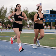 two women running on track