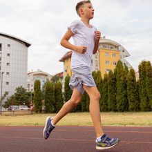 teen boy running laps on a track alone