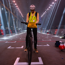 a guy on a bike on a lit up bridge