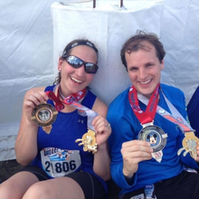 kate edwards and a man posing with race medals.