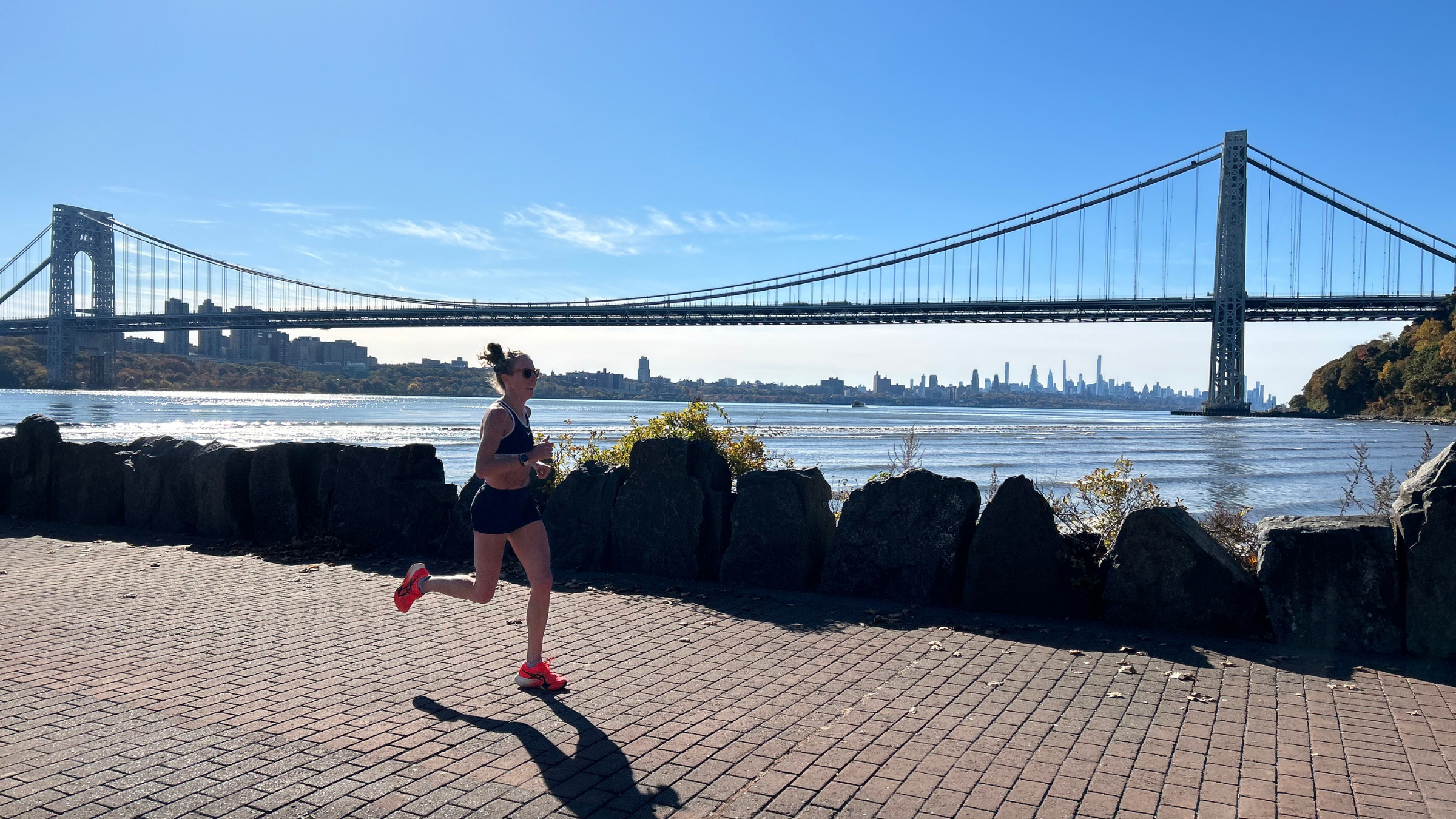 a woman runs against the New York City skyline