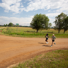 man and woman running on dirt road